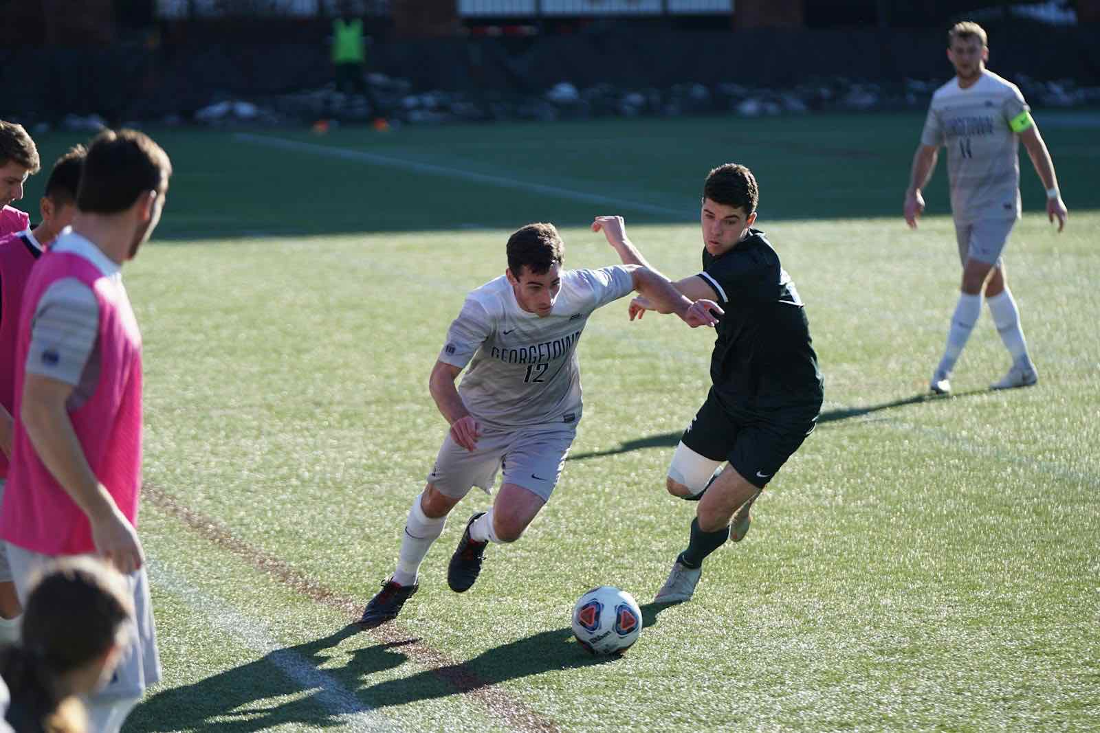 Footballers competing for the ball during a club match