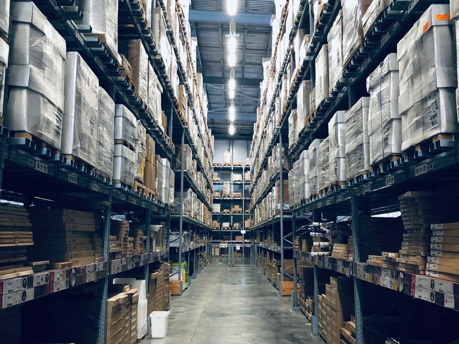 Wide aisle of a stocked distribution warehouse with racked cartons